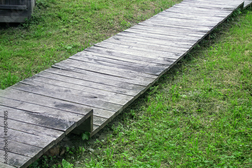 Path from the boards on the lawn. Boardwalk.