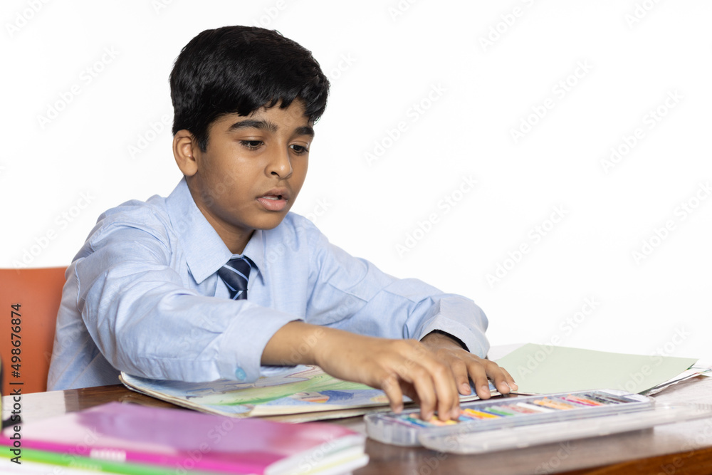 young boy from primary school studying seating in the classroom isolated on white background young boy from primary school studying seating in the classroom isolated on white background