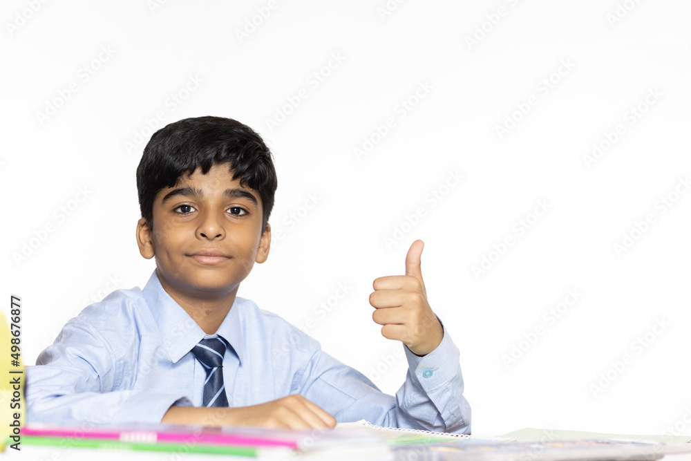 young boy from primary school studying seating in the classroom isolated on white background young boy from primary school studying seating in the classroom isolated on white background
