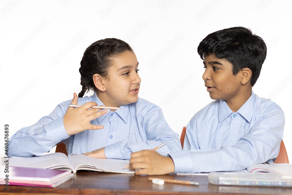 young girl and boy from primary school studying sharing explain learn in the classroom isolated on the white background young girl and boy from primary school studying sharing explain learn in the classroom isolated on the white background
