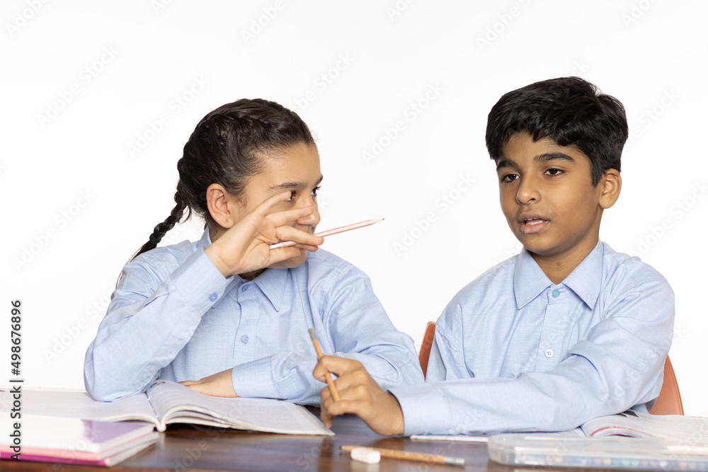 young girl and boy from primary school studying discussion in the classroom isolated on the white background young girl and boy from primary school studying discussion in the classroom isolated on the white background