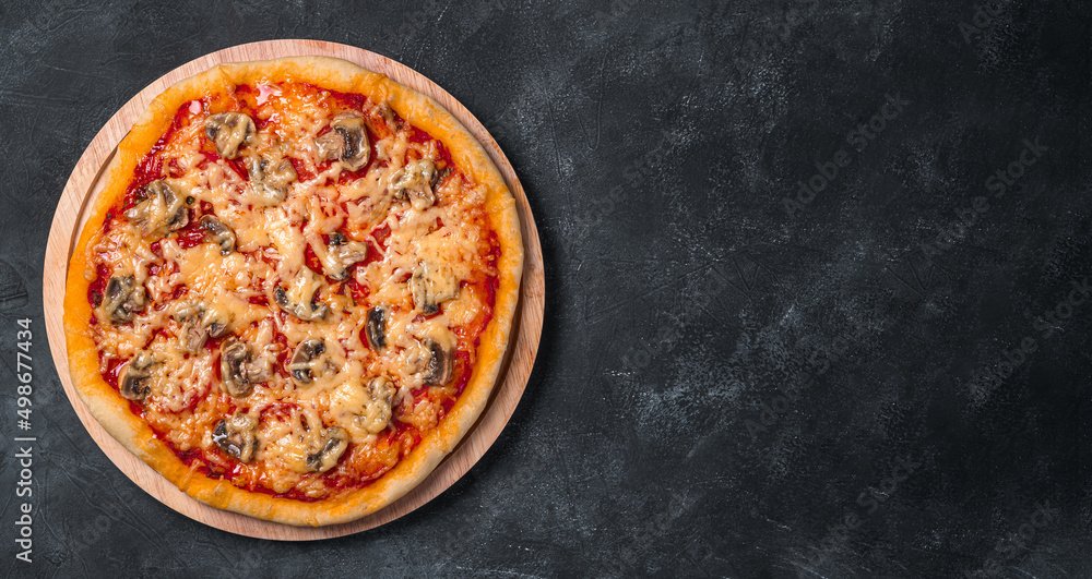 Juicy pizza with tomatoes, mushrooms, cheese and tomato sauce on a board on a dark background. Juicy pizza with tomatoes, mushrooms, cheese and tomato sauce on a board on a dark background.