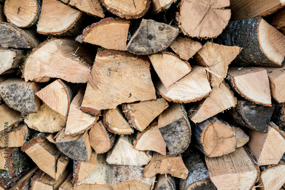 Background of stacked chopped wood logs. Pile of wood logs ready for winter. Wooden stumps, firewood stacked in heap Background of stacked chopped wood logs. Pile of wood logs ready for winter. Wooden stumps, firewood stacked in heap