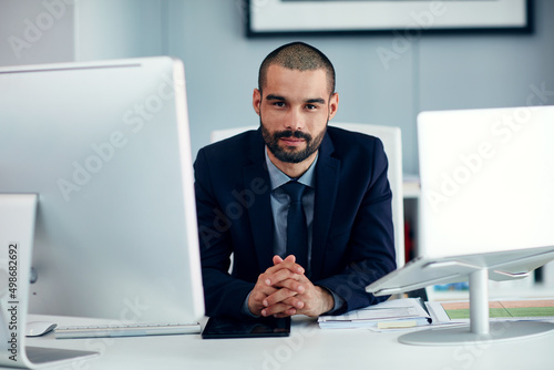 Lets get down to business. Portrait of a young businessman sitting at his desk in an office.
