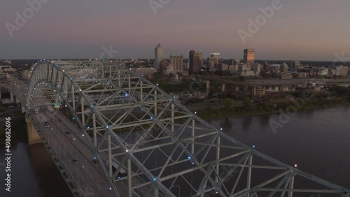 aerial cinematography of bridge with a city behind on a cool summer evening 