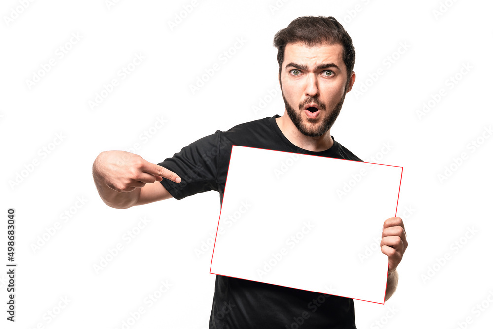 Look over there! Guy with open mouth points finger space for your text or ad on poster. Surprised man in black t-shirt shows advertisement in studio Look over there! Guy with open mouth points finger space for your text or ad on poster. Surprised man in black t-shirt shows advertisement in studio