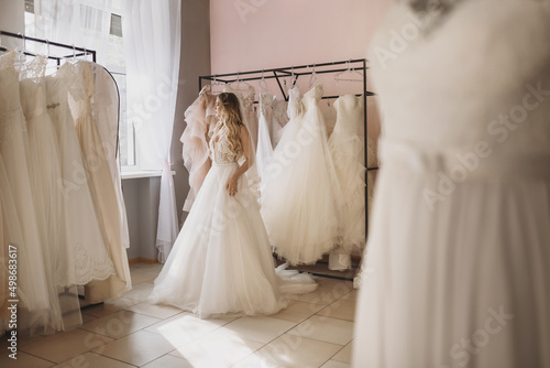 Fotografie Young blonde woman trying on a dress in wedding salon