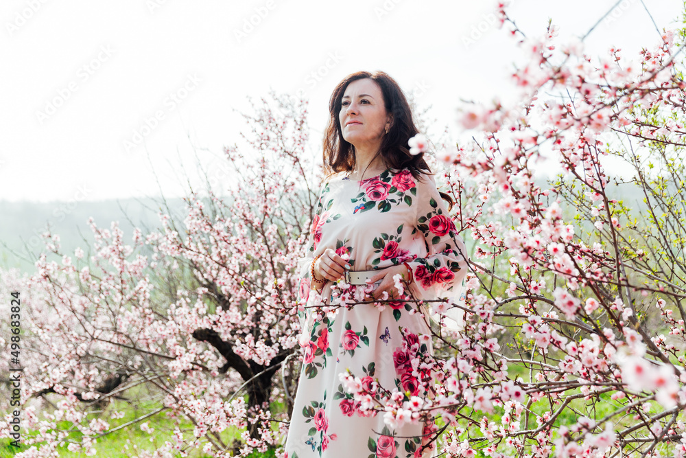 a woman in a garden of flowering trees in the spring a woman in a garden of flowering trees in the spring