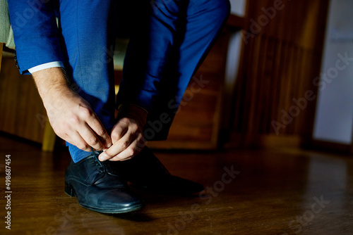 dressing shoe tying shoelaces blue men's suit