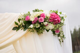 wedding arrangement on a curtain of roses hydrangeas eustoma