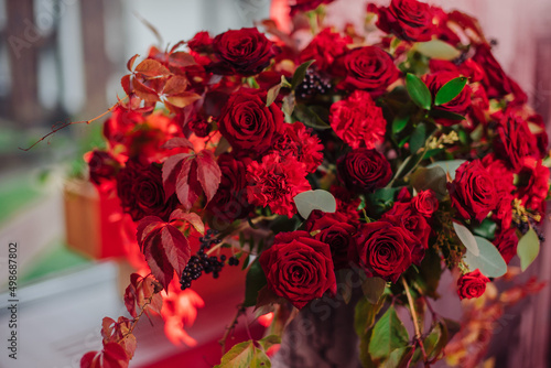 red floral arrangement in a vase of roses and carnations
