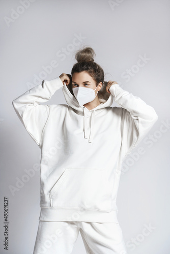 Young woman wearing white hoodie and ffp2 respirator mask