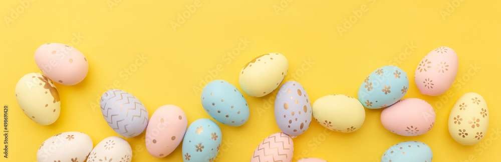 Easter colorful eggs on a yellow background. Top view. Easter card