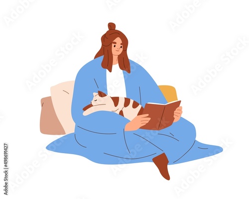 Happy woman reading book with cute cat sleeping on her. Pet owner covered wit...
