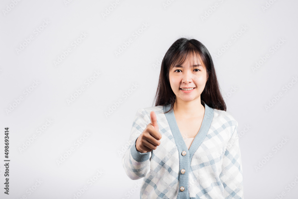 Happy woman smile showing finger thumbs up, Portrait Asian beautiful young female successful like finger gesture, OK sign to agree studio shot isolated on white background with copy space Happy woman smile showing finger thumbs up, Portrait Asian beautiful young female successful like finger gesture, OK sign to agree studio shot isolated on white background with copy space