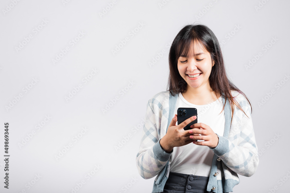 Woman excited read social network feedback on smartphone studio shot isolated white background, young female smiling typing sms message on mobile phone in social media Woman excited read social network feedback on smartphone studio shot isolated white background, young female smiling typing sms message on mobile phone in social media