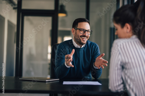 Smiling businessman explaining something to a female client. photo