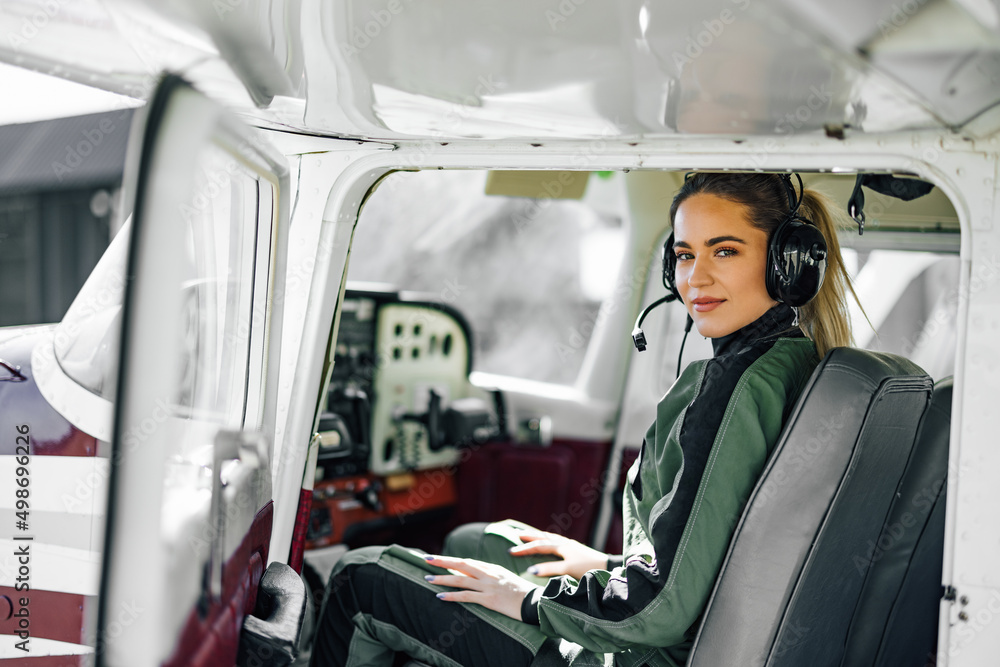 Delighted adult female captain, operating the plane in the cockp Delighted adult female captain, operating the plane in the cockp