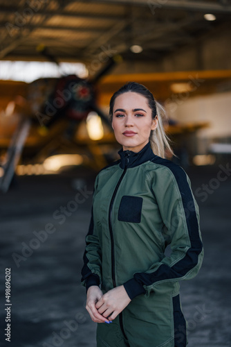 Girl posing for the camera, holding hands, pilot uniform.