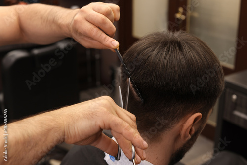 Professional hairdresser cutting man's hair in barbershop © New Africa