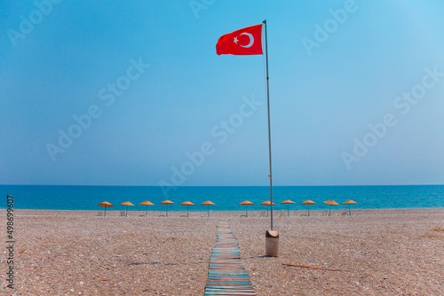 Red turkish national flag on empty sea beach