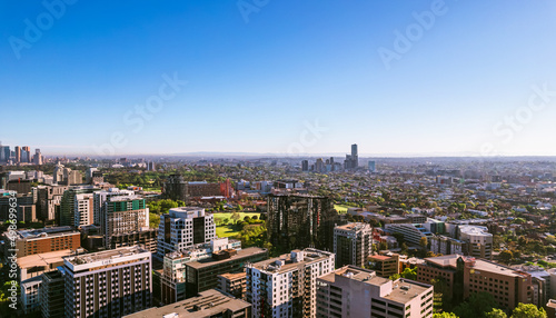 Aerial view of Melbourne cityscape with skyline against blue sky.