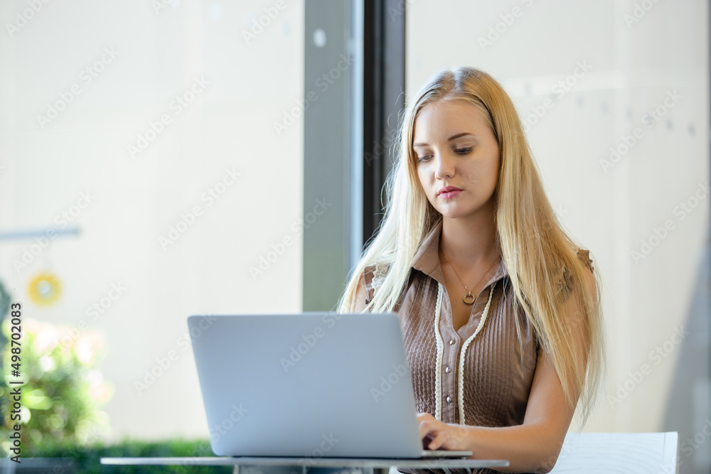 Beautiful woman with blond hair using computer laptop at office table. professional freelancer in workplace. Beautiful woman with blond hair using computer laptop at office table. professional freelancer in workplace.