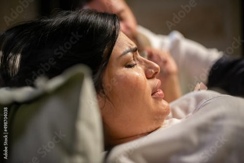 Slika na platnu Crying pregnant woman giving birth at home