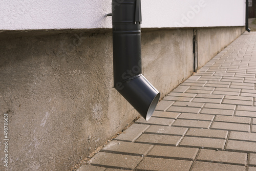 A gray drainpipe on the corner of a white house in dry weather. Fototapet