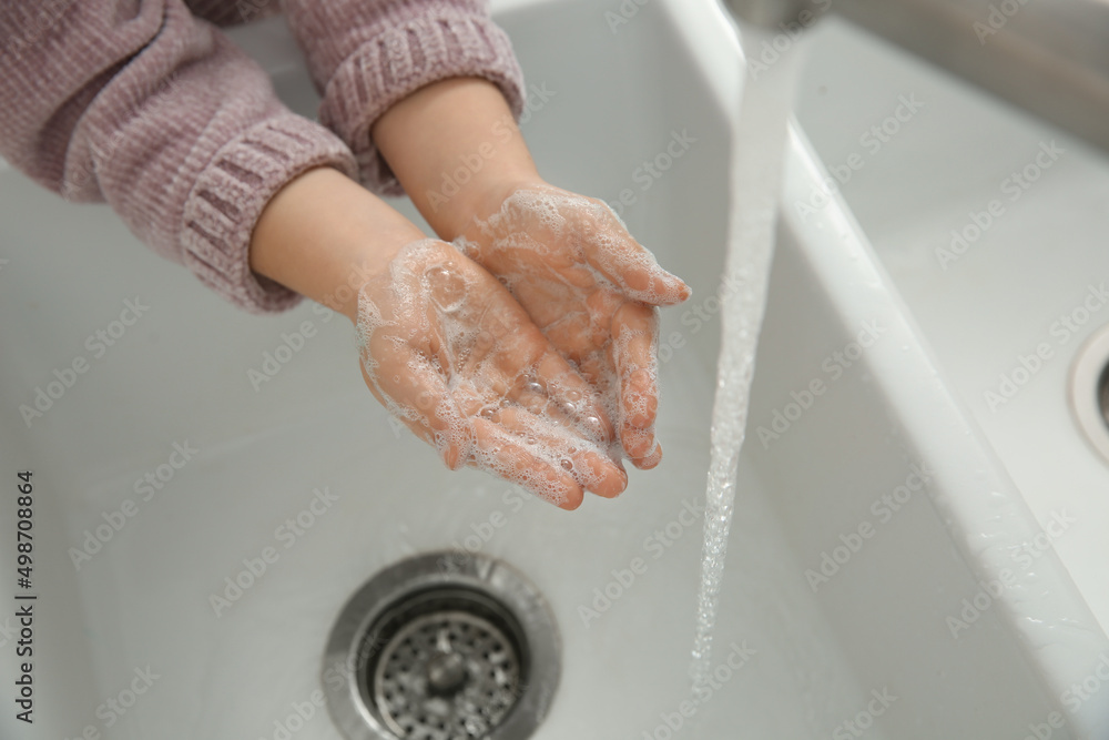 Fototapeta premium Little girl washing hands with liquid soap, closeup