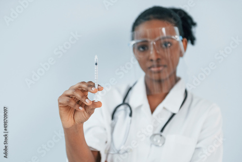 Medicine worker. Young african american woman is against white background