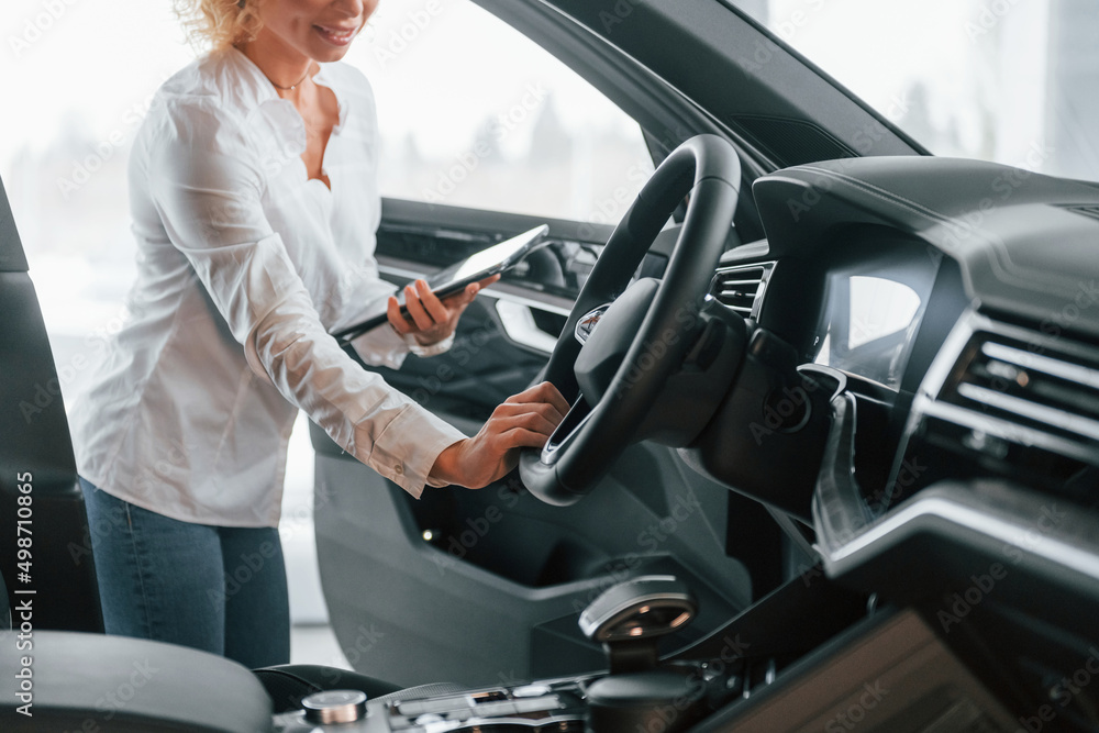 View of vehicle interior. Woman with curly blonde hair is in autosalon View of vehicle interior. Woman with curly blonde hair is in autosalon