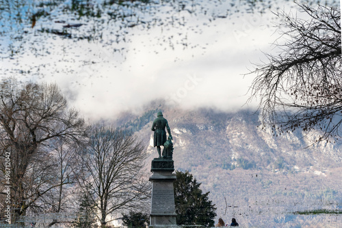 Reflection in water of the Claude Louis Berthollet statuein outdoor park under clear blue sky in Annecy, France