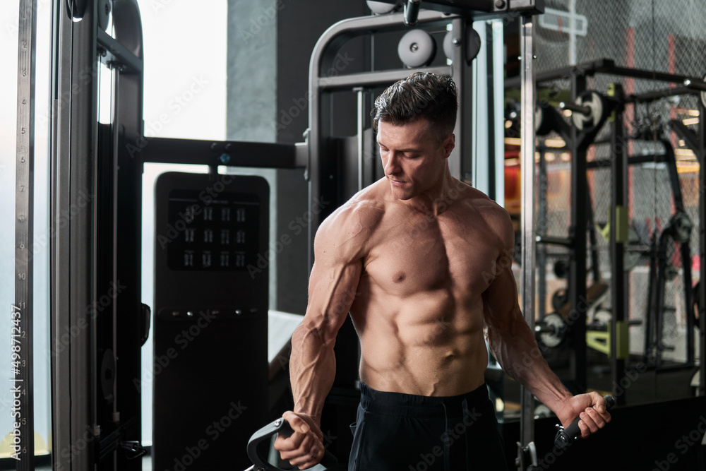 Muscular man working out in gym, strong male torso abs. Muscular man working out in gym, strong male torso abs.