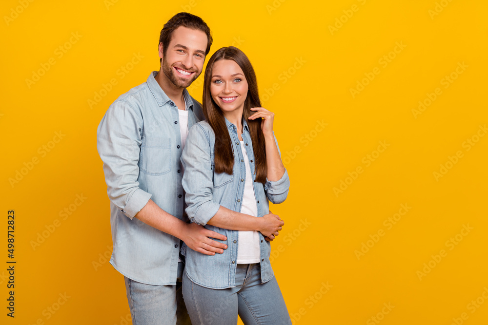 Portrait of attractive cheerful couple married spouses hugging copy blank space isolated over bright yellow color background Portrait of attractive cheerful couple married spouses hugging copy blank space isolated over bright yellow color background