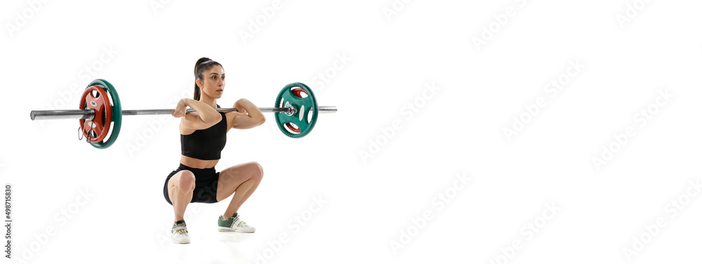 Obraz premium Full length portrait of muscled woman in sportswear exercising with a weight, barbell isolated on white background. Sport, weightlifting concept