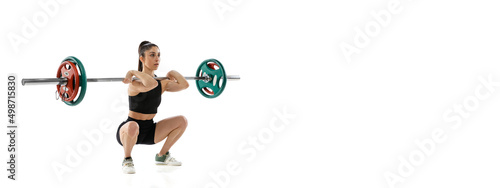 Full length portrait of muscled woman in sportswear exercising with a weight, barbell isolated on white background. Sport, weightlifting concept