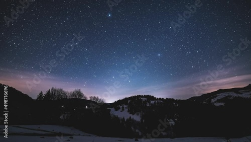 Magic blue night sky with million stars of milky way galaxy and sunrise in winter mountains nature Night to Day Time lapse