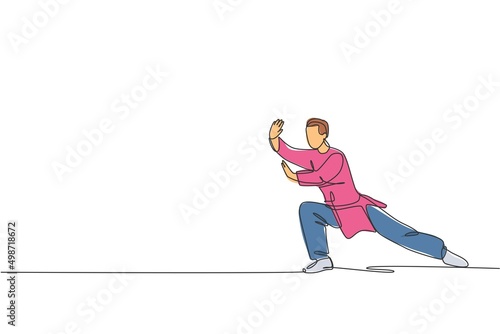 Single continuous line drawing of young man wushu fighter, kung fu master in uniform training tai chi stance at dojo center. Fighting contest concept. Trendy one line draw design vector illustration