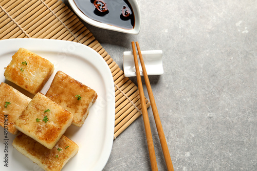 Delicious turnip cake served on grey table. Space for text photo