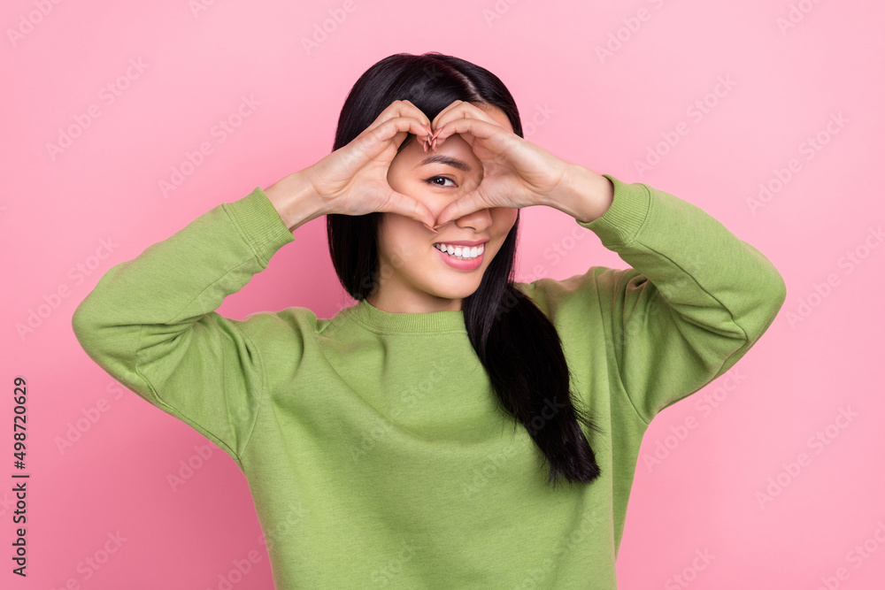Photo of nice brunette millennial lady show heart wear green pullover isolated on pink color background Photo of nice brunette millennial lady show heart wear green pullover isolated on pink color background