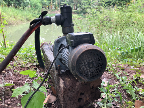 An old water pump machine in the forest.