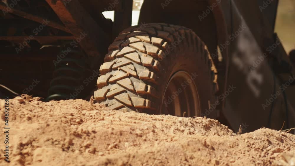 SUV is slowly moving down sandy slope, closeup, back view. Car goes down slope on race in desert. Utility vehicle goes hill off-road SUV is slowly moving down sandy slope, closeup, back view. Car goes down slope on race in desert. Utility vehicle goes hill off-road