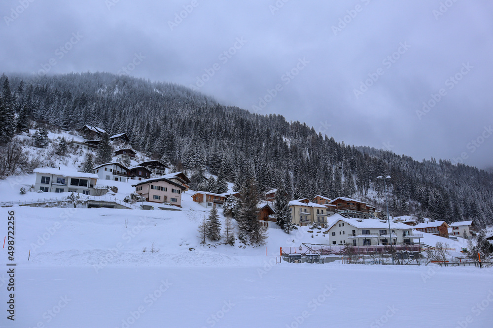 View to the foggy, snowy Landscape and the VIllage of Churwalden, Switzerland in Wintertime