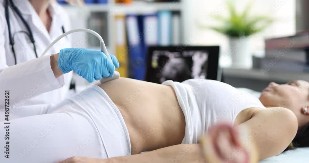 Doctor diagnoses pregnant woman on ultrasound machine Doctor diagnoses pregnant woman on ultrasound machine