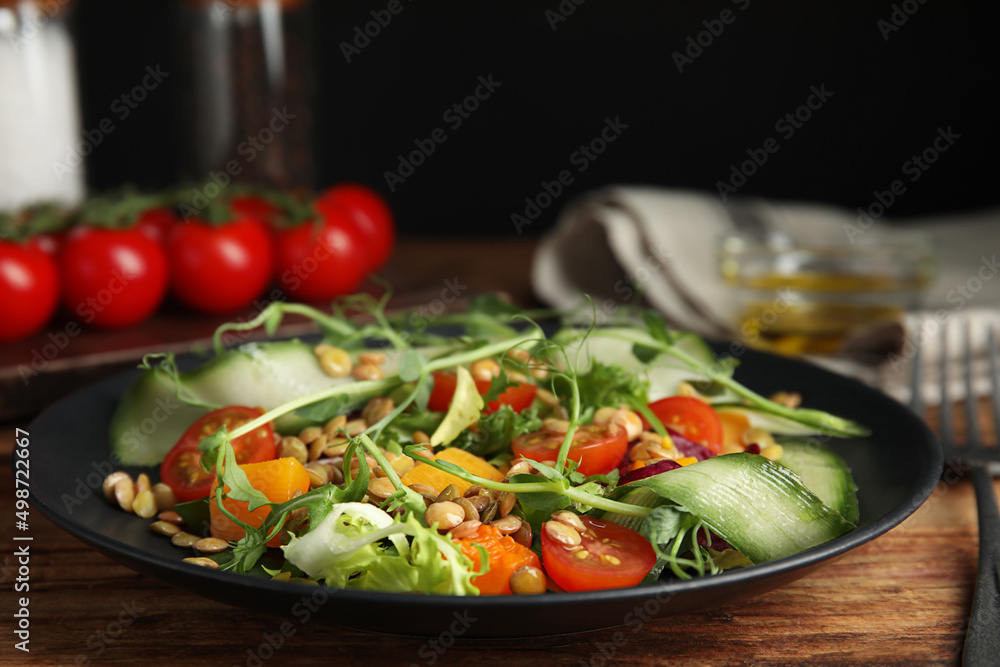 Delicious salad with lentils and vegetables on wooden table