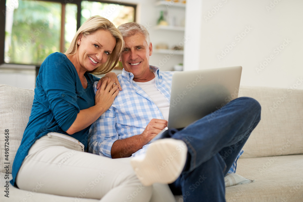 Bonding while browsing. Portrait of a mature couple using a laptop together at home.