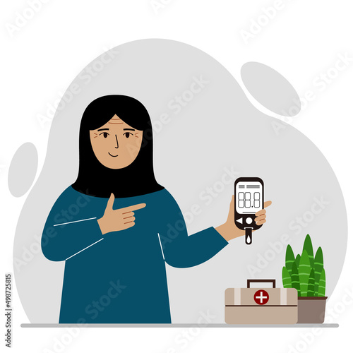 Happy muslimwoman holds a glucometer in his hand. The concept of blood sugar control, diabetic.