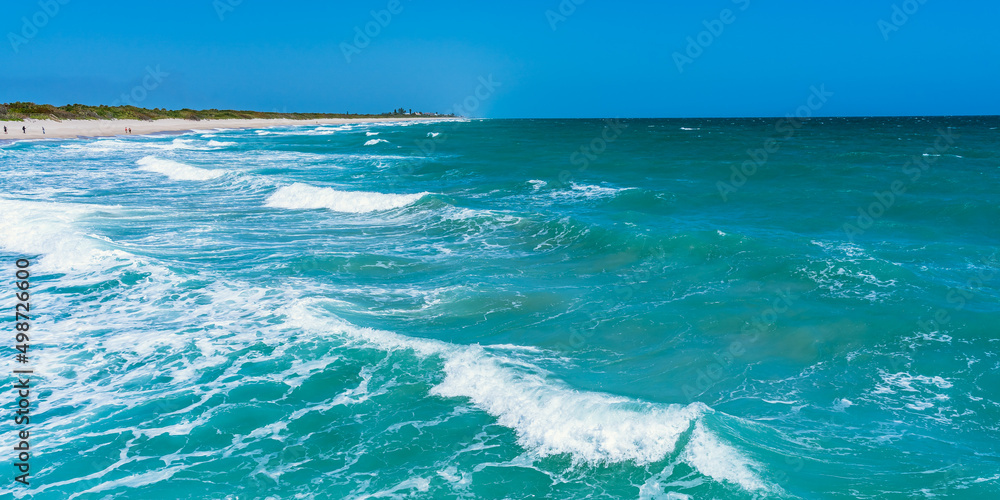 Panorama of the Atlantic Ocean in sunny windy weather. Beautiful green waves crash on a sandy beach in Florida Panorama of the Atlantic Ocean in sunny windy weather. Beautiful green waves crash on a sandy beach in Florida