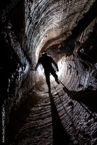 Caver on the rope in the pitch inside of a cave